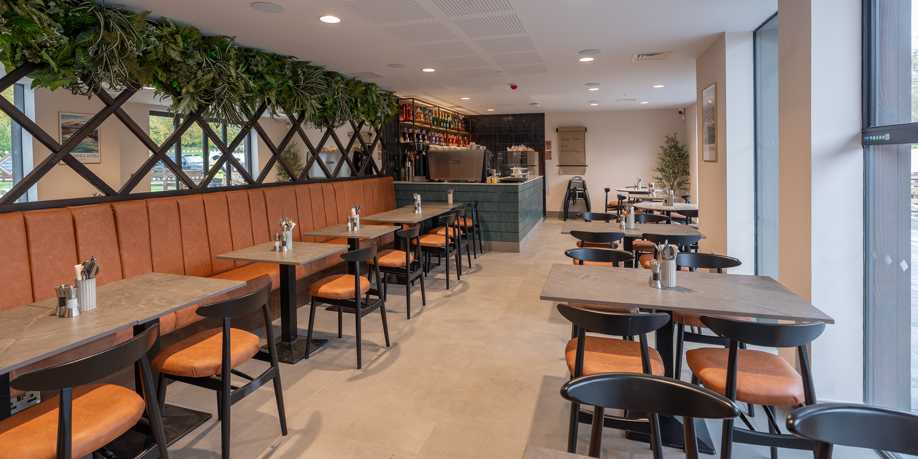 Modern restaurant interior with tables, chairs, and decorative elements.