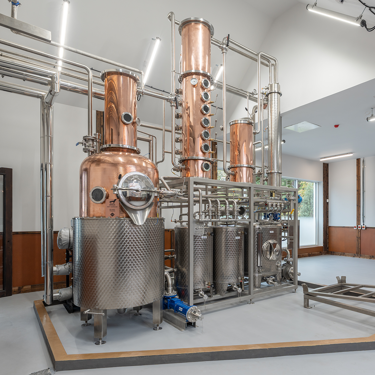 Copper and stainless steel distillation equipment in a modern facility