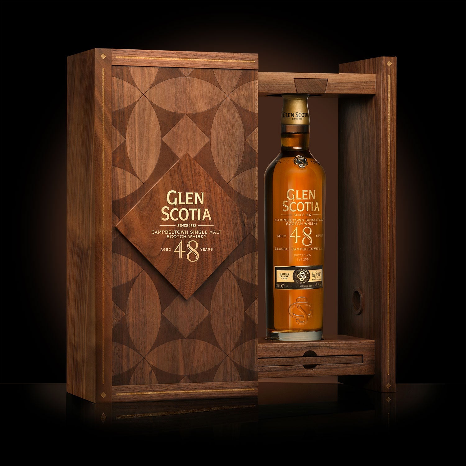 A bottle of Glen Scotia Old & Rare 48 Year Old Whisky is displayed in an elegant wooden case adorned with intricate geometric designs. The open case reveals the gold-hued bottle standing upright against a black background.